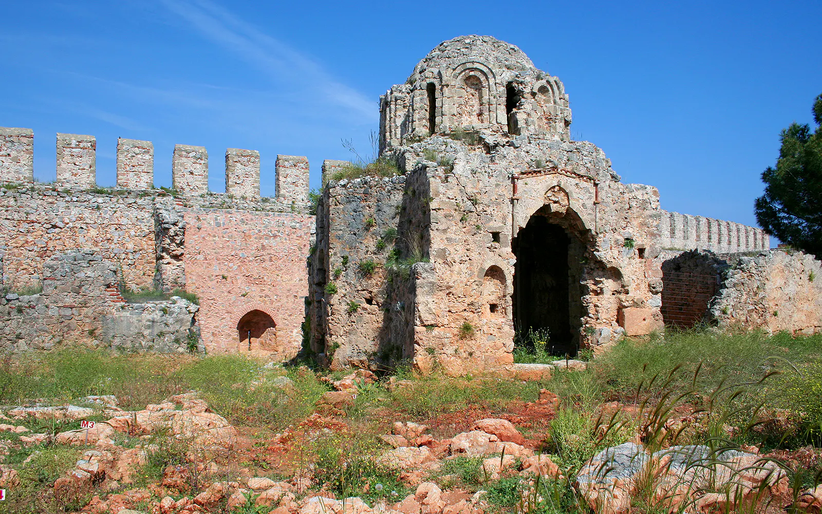 Ancient stone ruins at Alanya Castle, Turkey, with a clear blue sky.