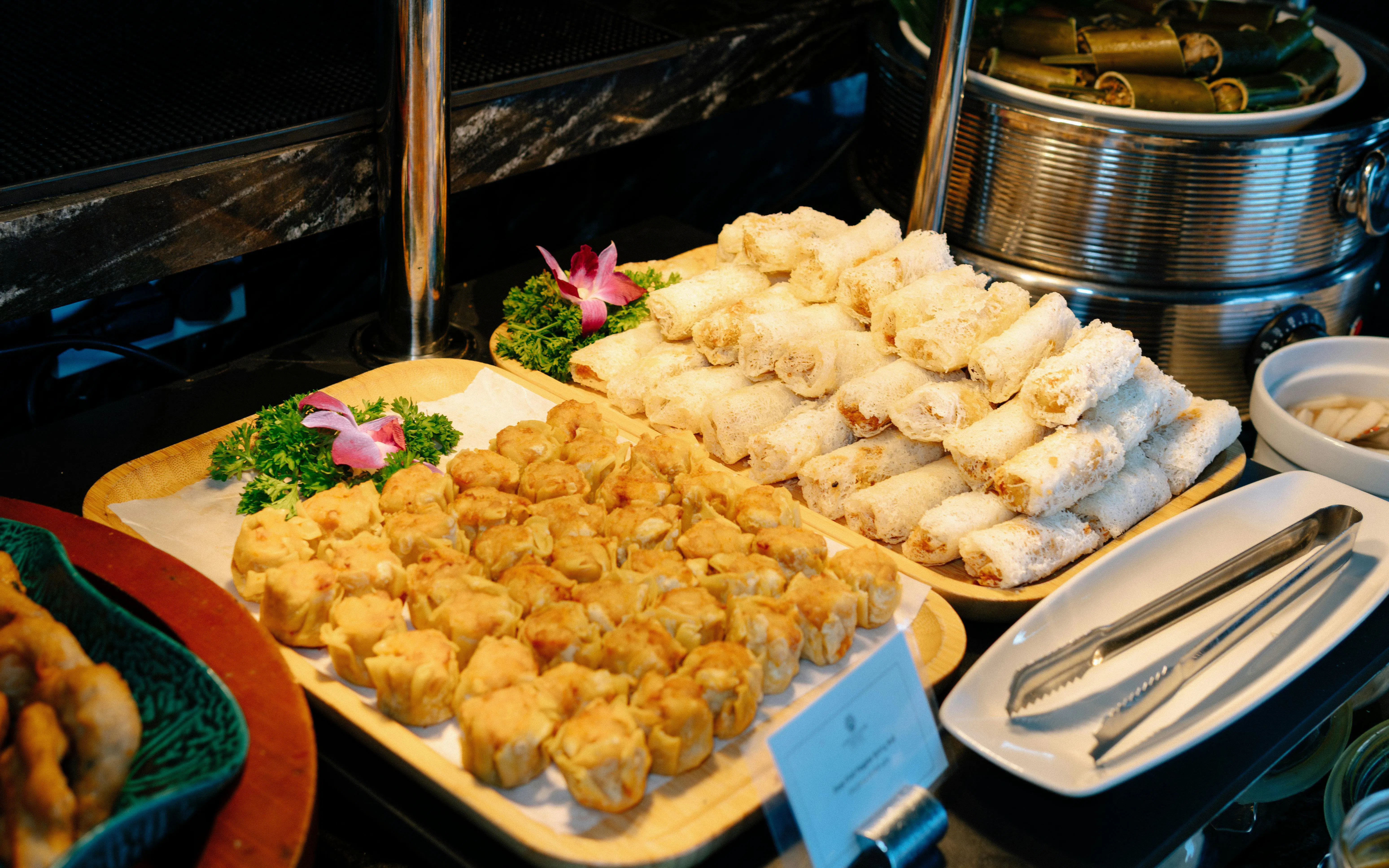 Vietnamese spring rolls and dumplings on a buffet aboard Ha Long Bay 5-Star Ambassador Cruise.