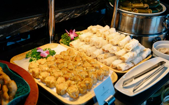 Vietnamese spring rolls and dumplings on a buffet aboard Ha Long Bay 5-Star Ambassador Cruise.
