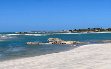 Pontal de Maceió beach with clear blue water and sandy shore, Fortim, Brazil.