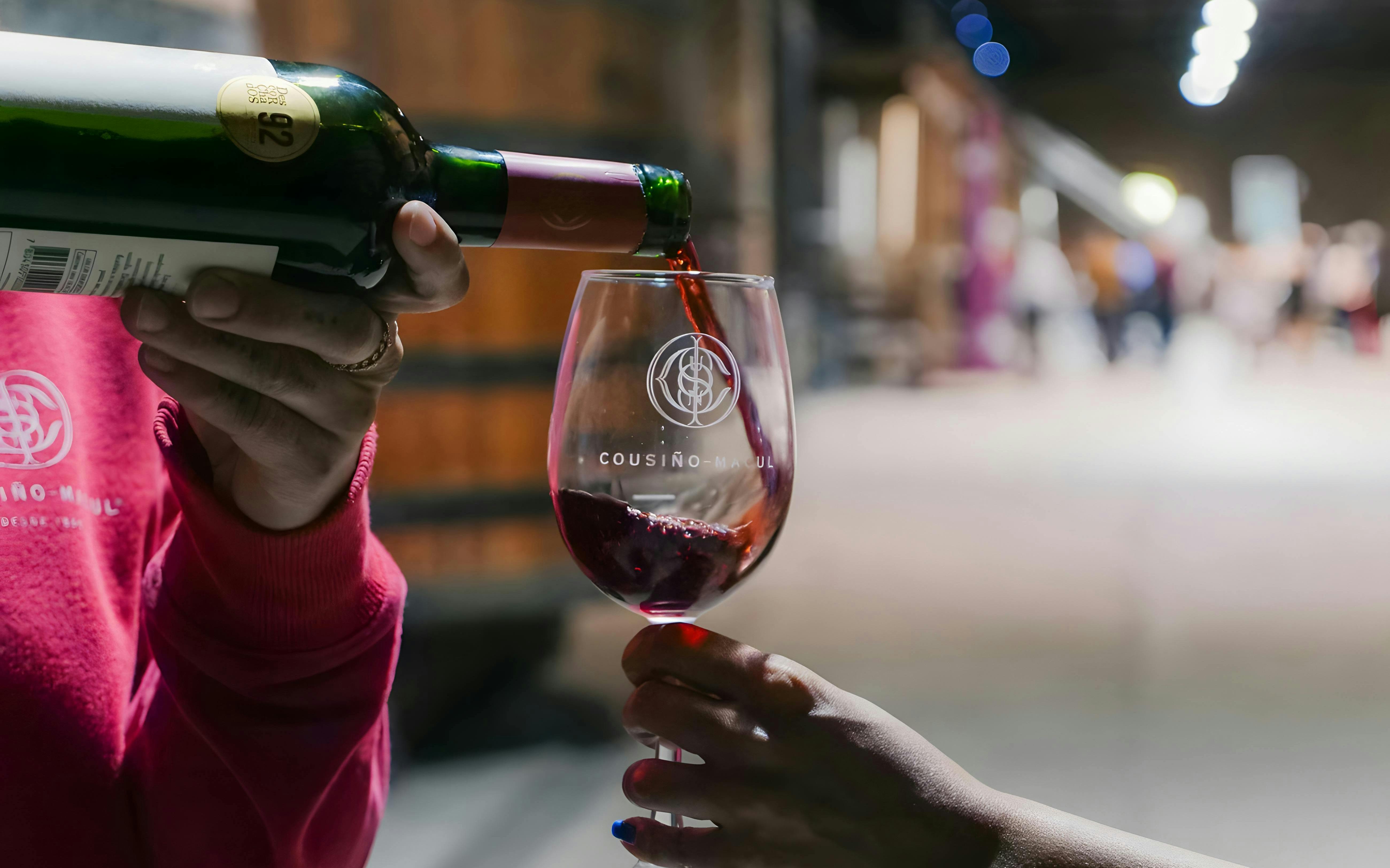 Tourist sampling wine at Cousiño Macul winery in Chile.