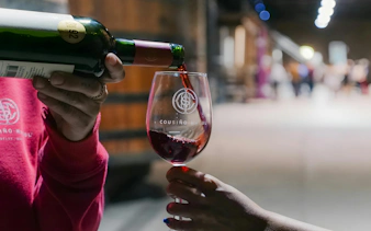 Tourist sampling wine at Cousiño Macul winery in Chile.