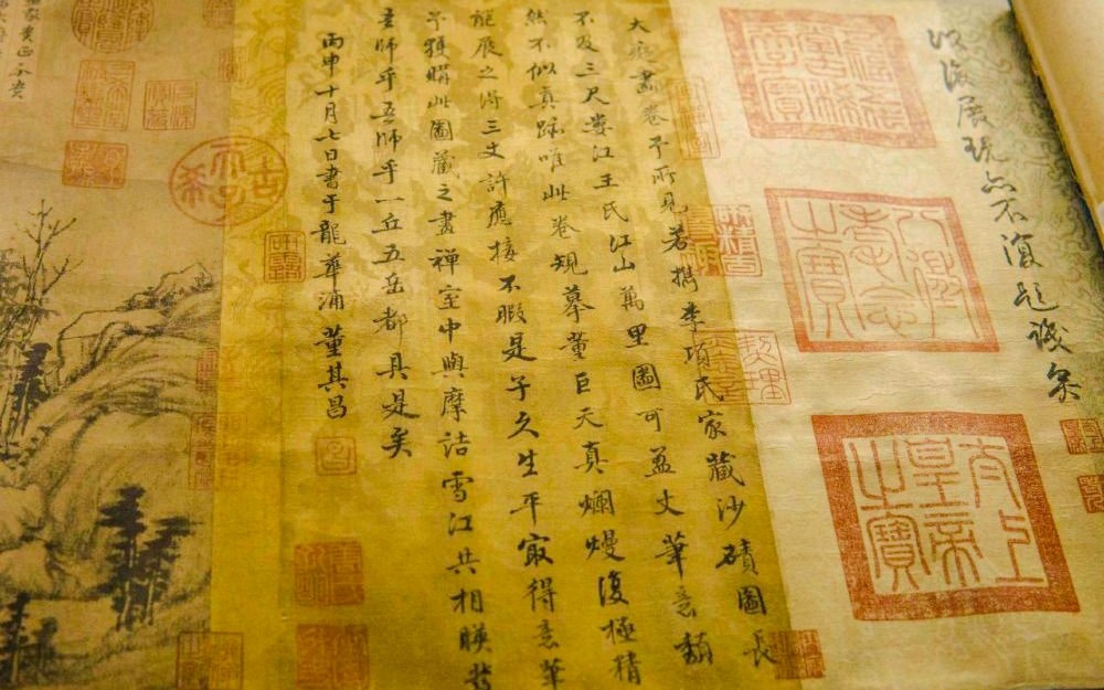 Ancient Chinese scroll with calligraphy and landscape illustration.