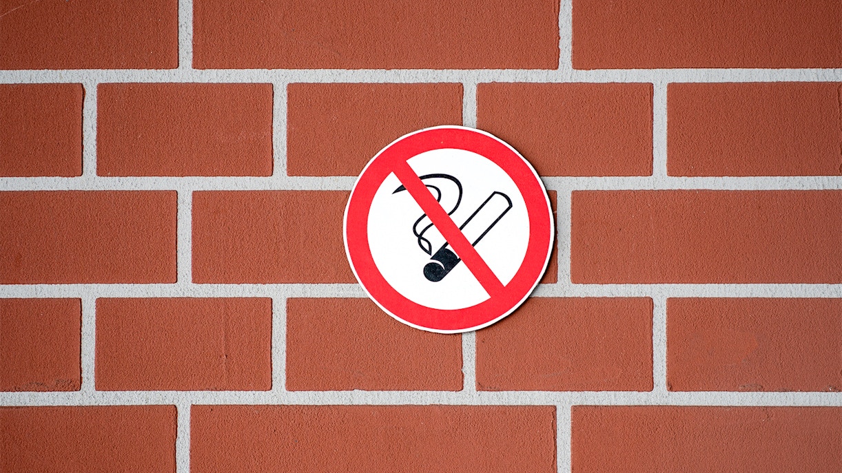 No smoking sign on a brick wall.