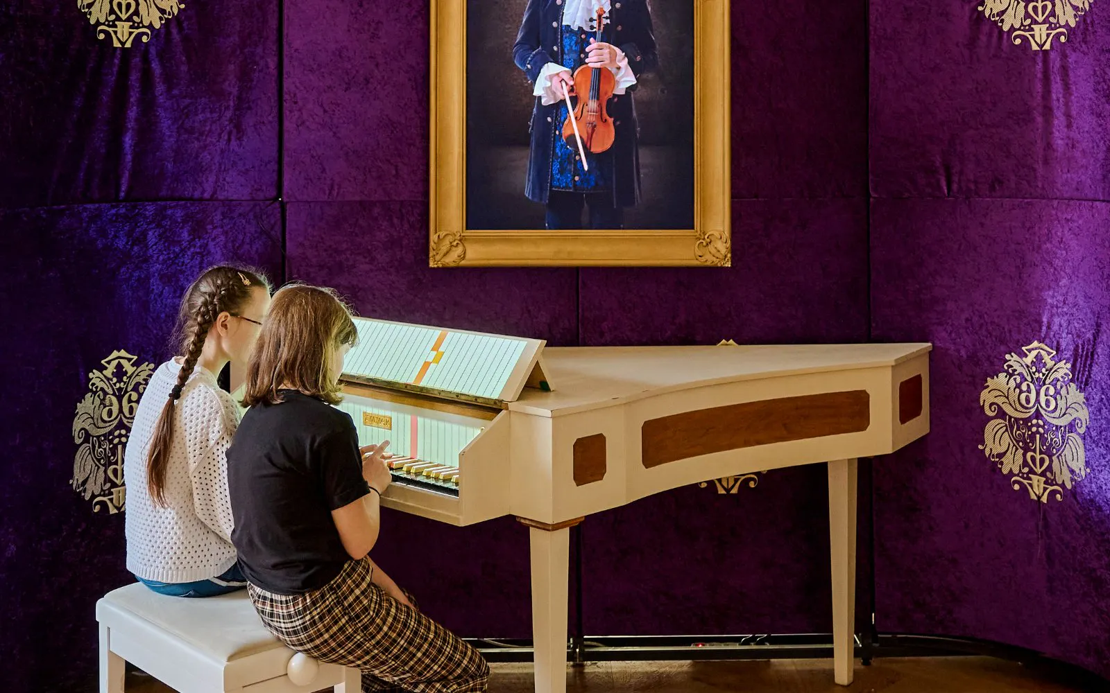Guests interacting with a musical exhibit at Mozart Interactive Museum in Prague.