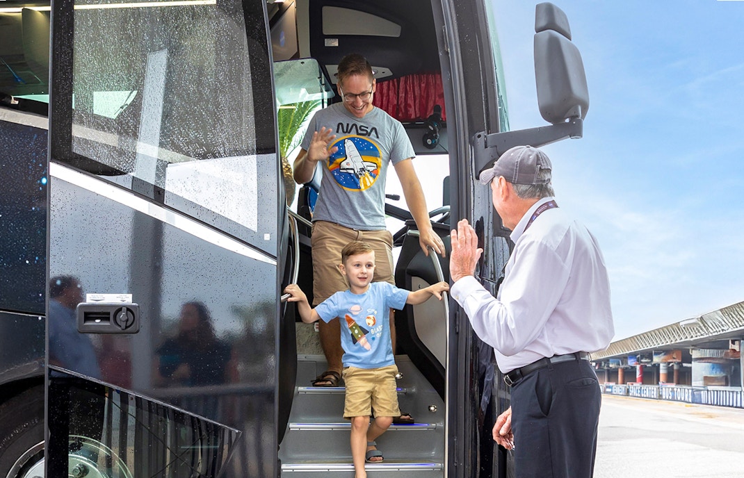 Visitors exploring a rocket exhibit at Kennedy Space Center, Florida, with guided tour tickets.