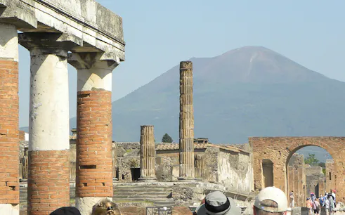 Ancient ruins of Pompeii with Mount Vesuvius in the background, part of a tour from Rome.