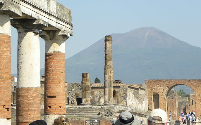 Ancient ruins of Pompeii with Mount Vesuvius in the background, part of a tour from Rome.