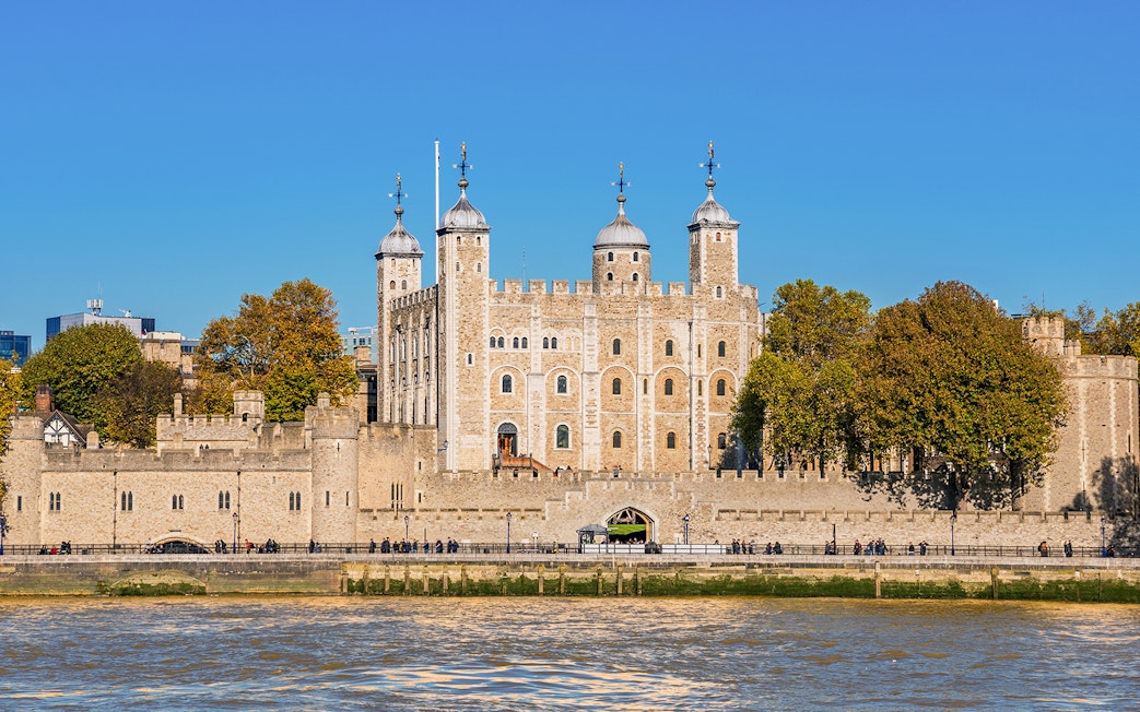 Tower of London exterior with river view and surrounding trees.