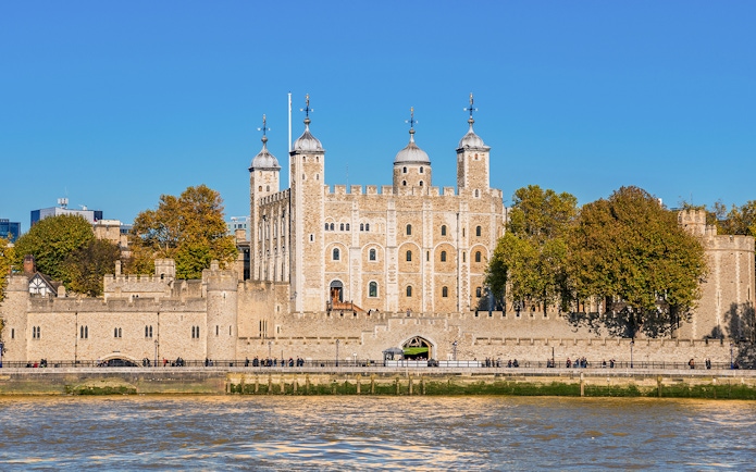 Tower of London exterior with river view and surrounding trees.