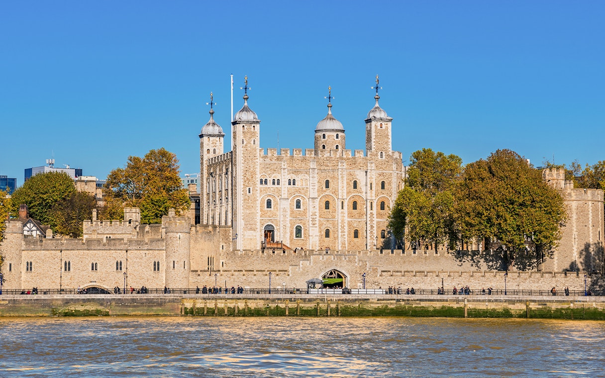Tower of London exterior with river view and surrounding trees.