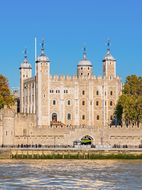 Tower of London exterior with river view and surrounding trees.