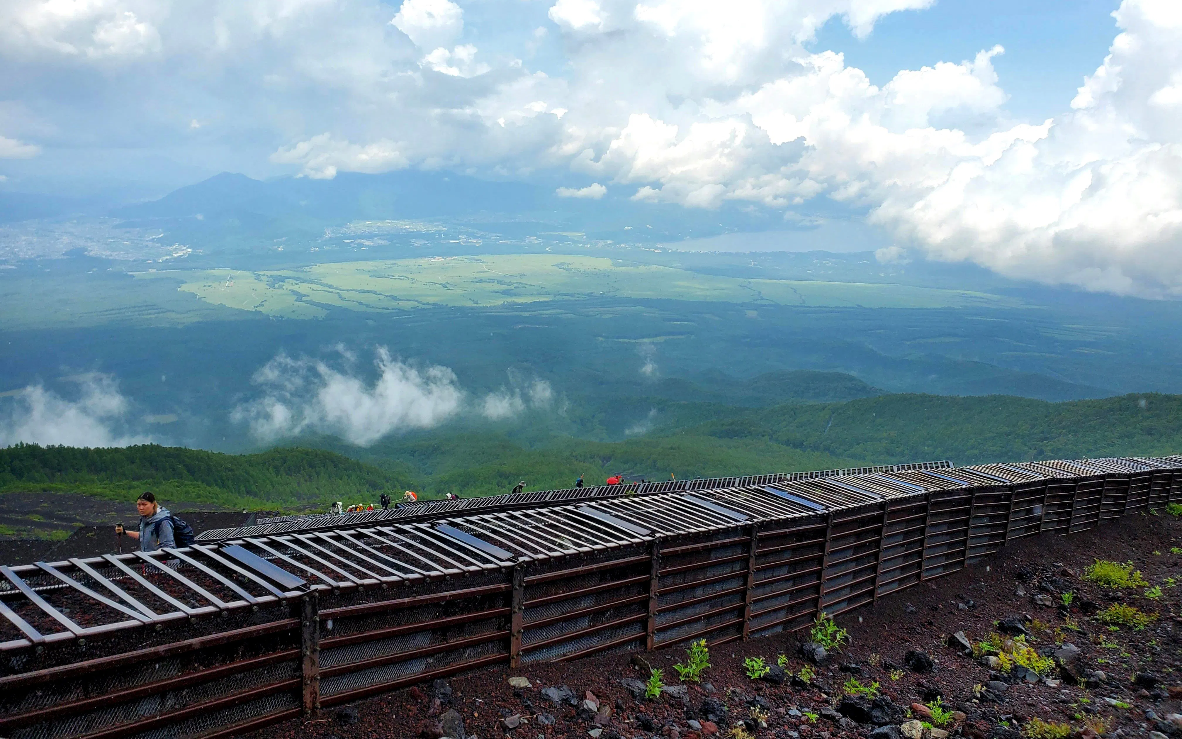 Climbers ascending Mt. Fuji with expansive views of the surrounding landscape.