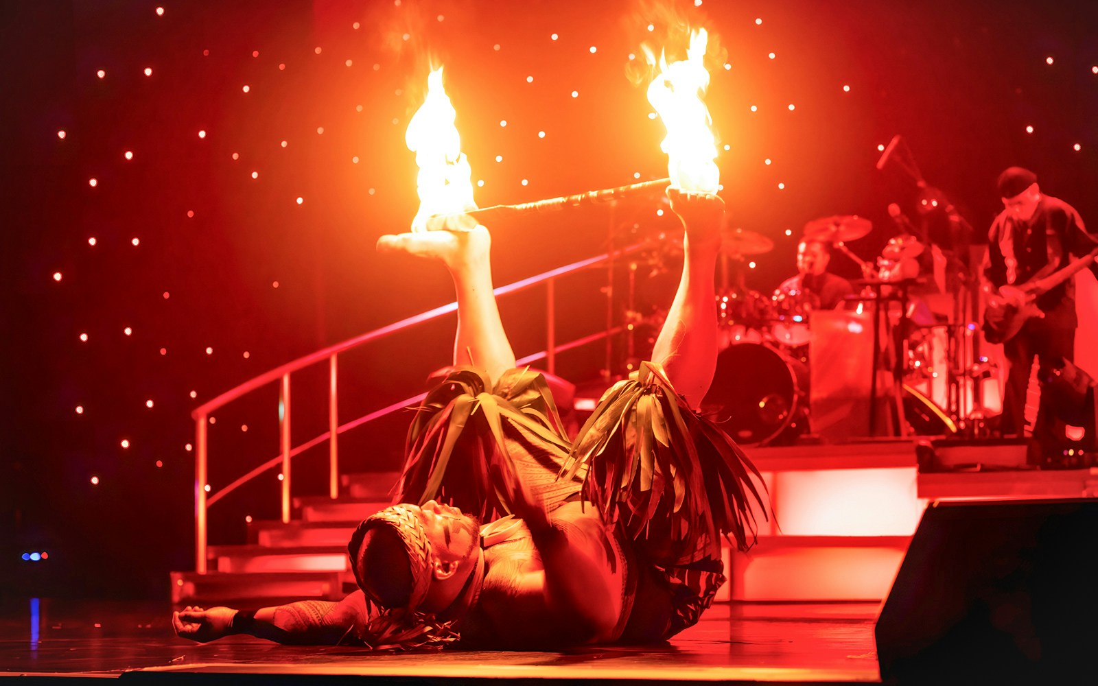 Fire dancer performing with flames on stage at Rock-A-Hula show.