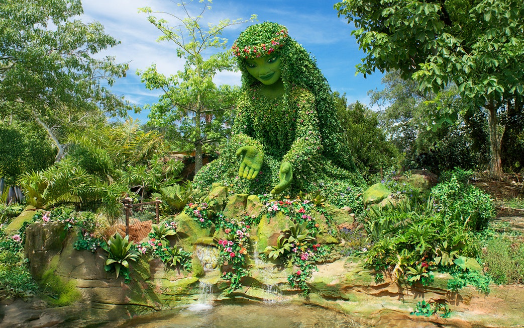 Giant green sculpture inspired by Moana surrounded by lush plants at Walt Disney Resort Orlando.