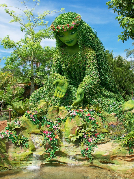 Giant green sculpture inspired by Moana surrounded by lush plants at Walt Disney Resort Orlando.