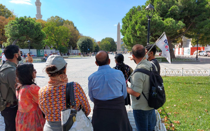 Tour group in Istanbul viewing the Obelisk of Theodosius with E-pass guide.