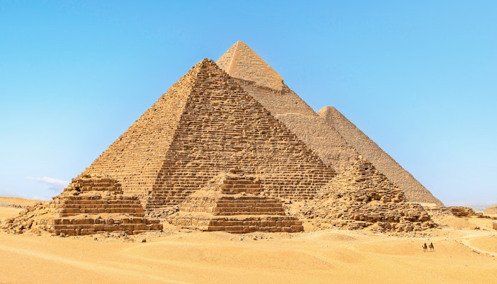 Pyramids of Giza in Egypt under a clear blue sky.