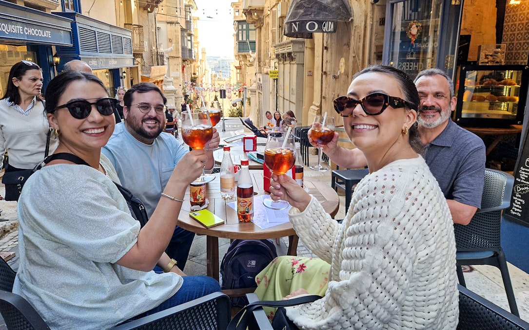 Group enjoying drinks at an outdoor café on a Valletta food tour.