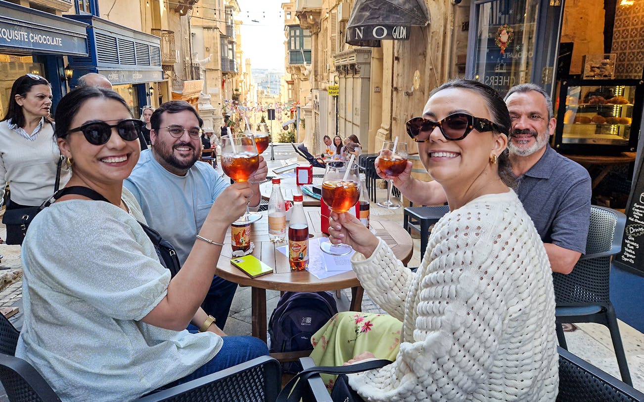 Group enjoying drinks at an outdoor café on a Valletta food tour.