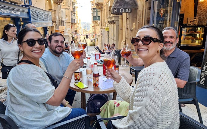 Group enjoying drinks at an outdoor café on a Valletta food tour.