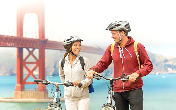 Couple biking near Golden Gate Bridge, San Francisco, with SightSeeing Flex Pass.