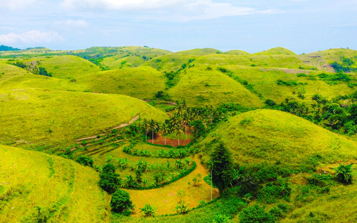 Scenic view of lush green hills on Nusa Penida Island during a private tour.
