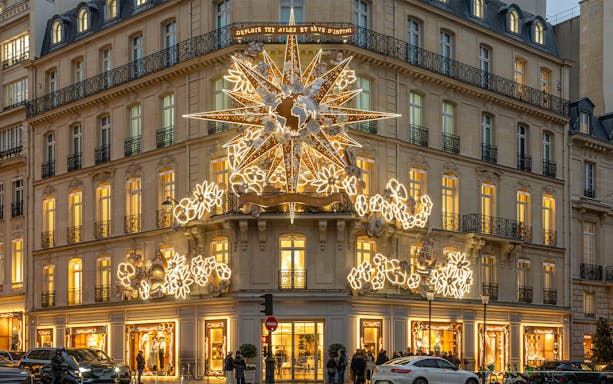 Paris building adorned with festive Christmas lights during a holiday tour.