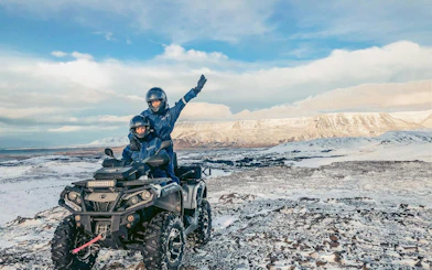 ATV riders on snowy terrain with mountain views, Twin Peaks tour, Reykjavik.