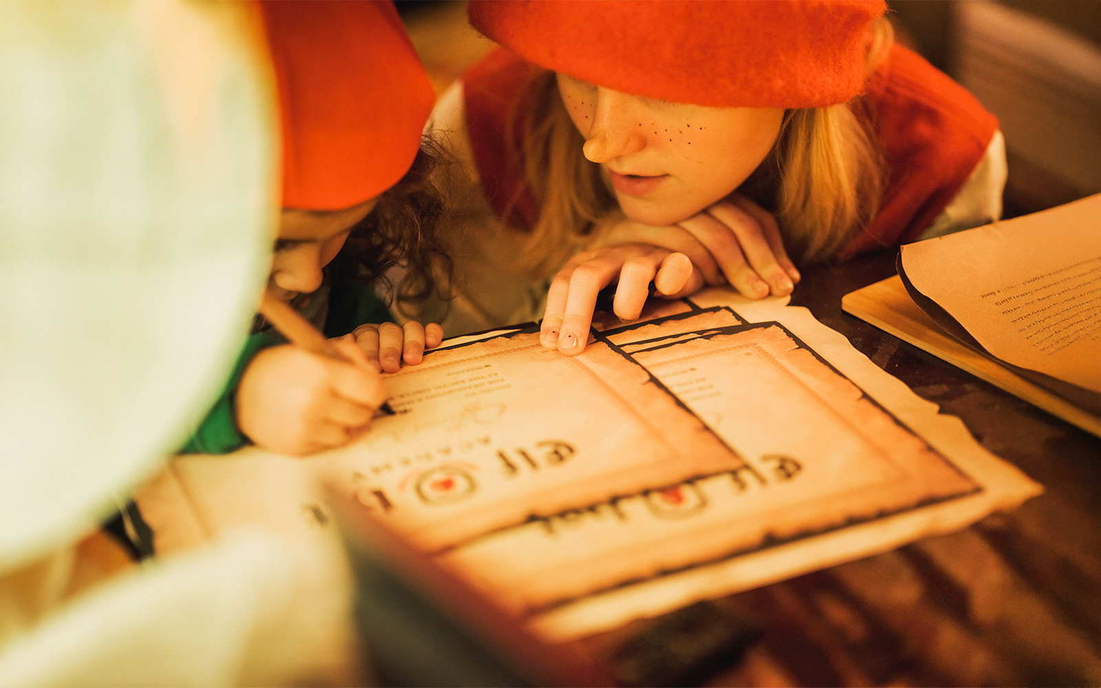 Children writing certificates at Elf Hat Academy in Santa's Village.