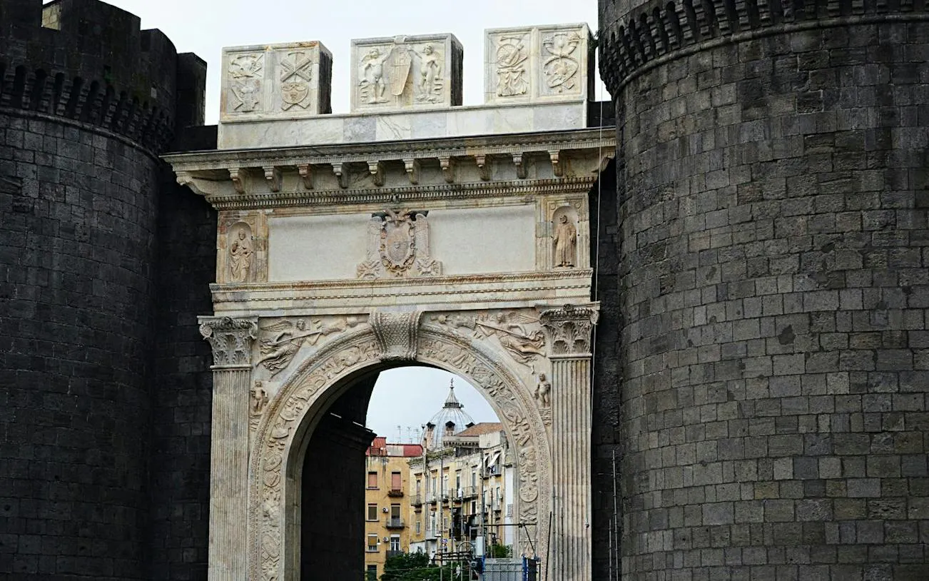 Medieval stone archway at Castel Nuovo, Naples, part of a self-guided city exploration game.