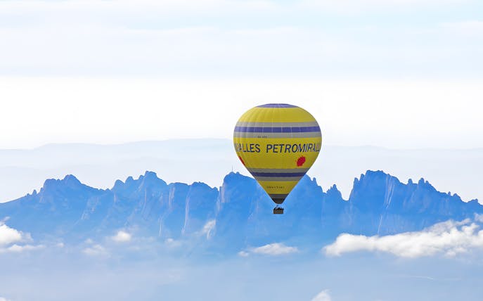 Hot air balloon flying over Montserrat mountains, Catalonia.