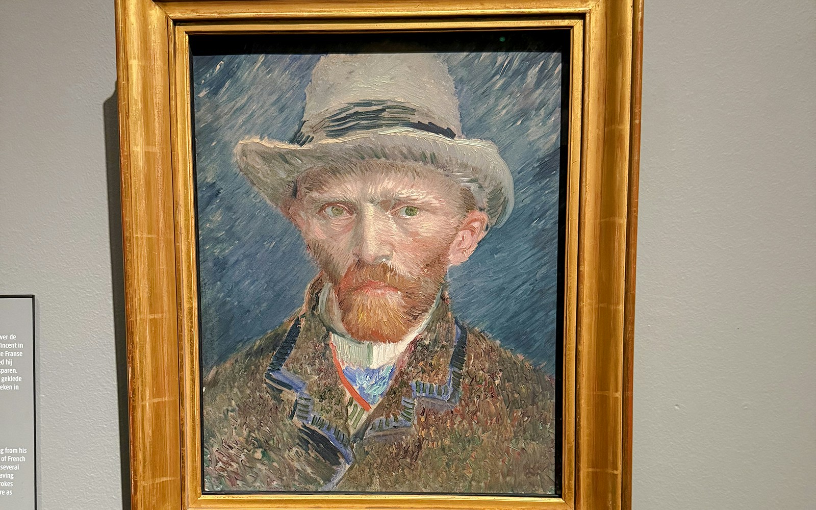 Self-portrait by Vincent van Gogh, 1887, featuring the artist in a hat with a textured background.