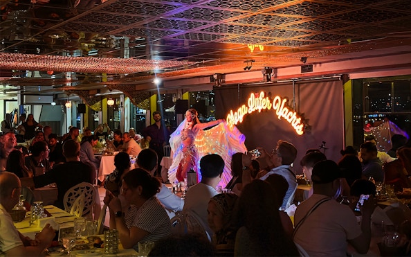 Belly dancer performing on a Bosphorus dinner cruise with guests seated at private tables.
