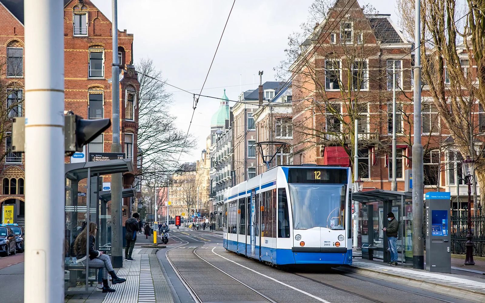 Tram in Amsterdam city center near historic buildings, showcasing public transport.