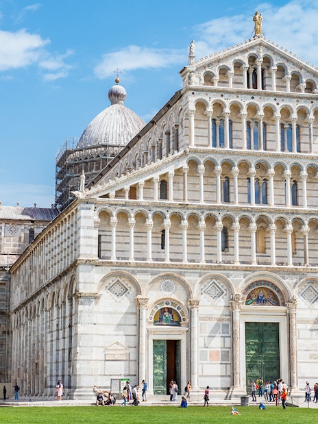 Pisa Cathedral in the Square of Miracles, Pisa, with visitors exploring the site.