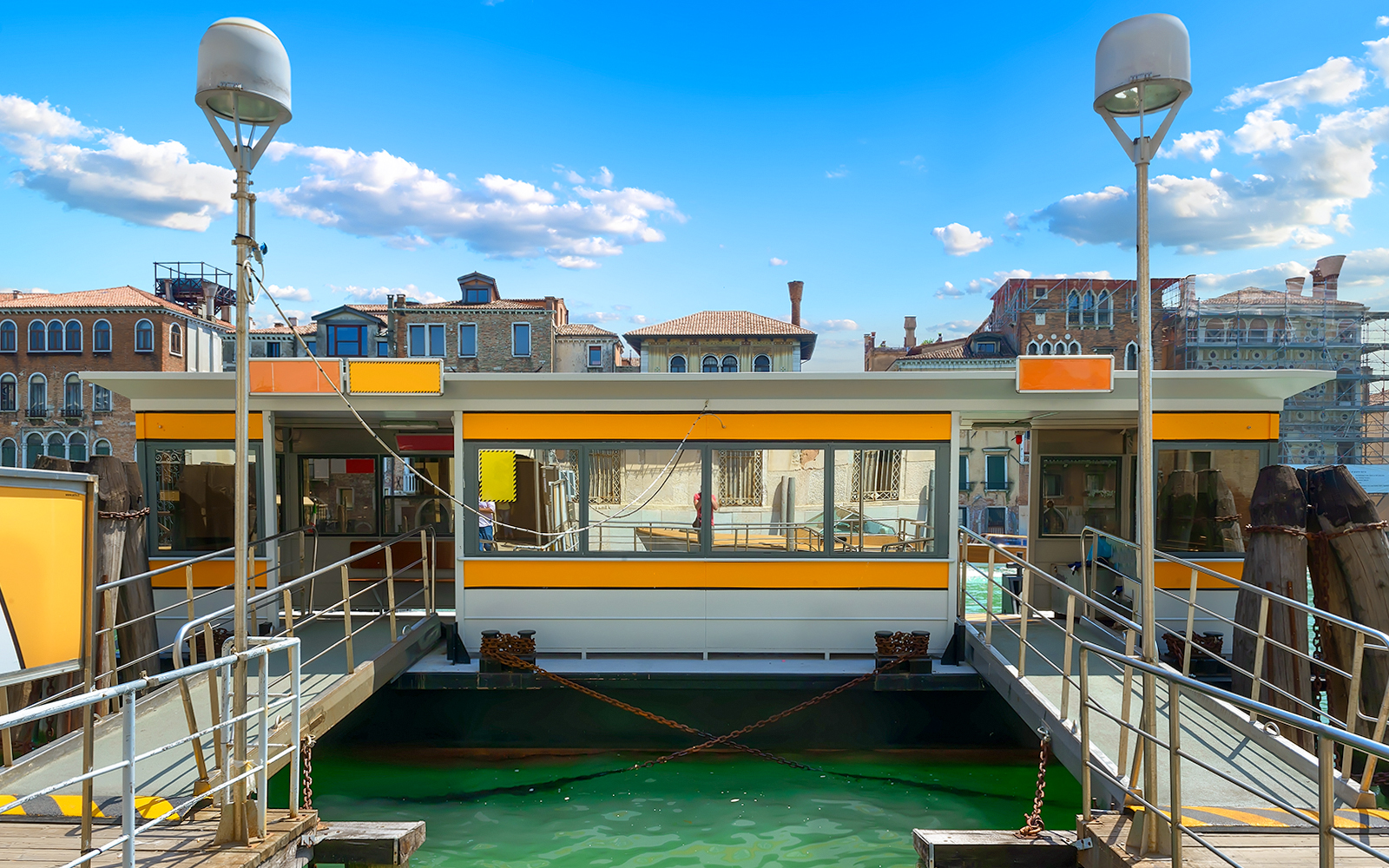 Vaporetto stop in Venice with bright yellow signage.
