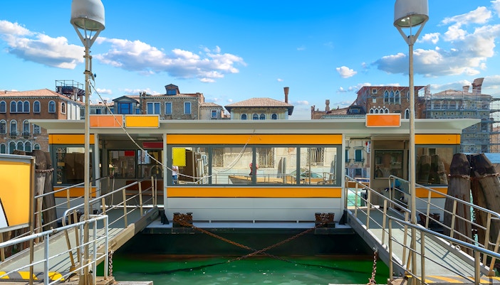 Vaporetto stop in Venice with bright yellow signage.