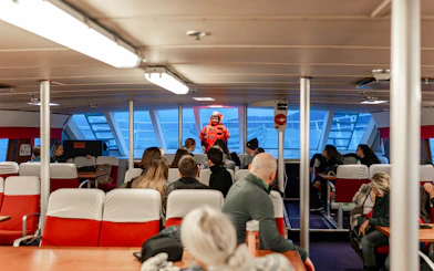 Guests seated inside a cruise with a marine guide during a responsible whale watching tour.