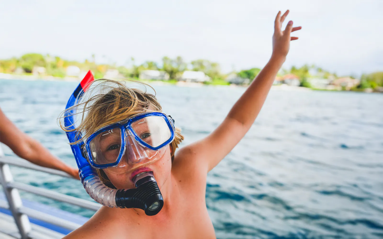Kid wearing snorkel gear on a boat near Kohala Coast, Big Island.