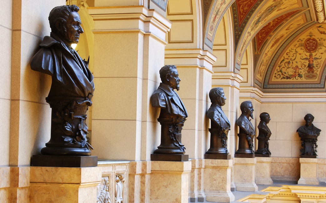 Busts lining the ornate hallway of the National Prague Museum interior.