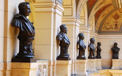 Busts lining the ornate hallway of the National Prague Museum interior.