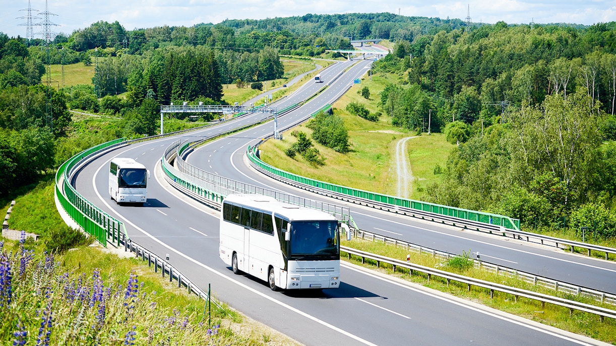 Bus traveling on highway through lush countryside towards Chenonceau Castle.