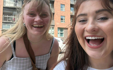 Two people smiling during the Manchester 80s & 90s music city exploration game.