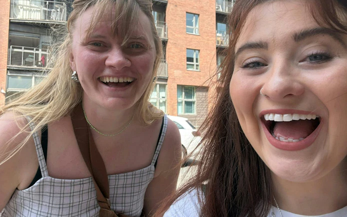 Two people smiling during the Manchester 80s & 90s music city exploration game.