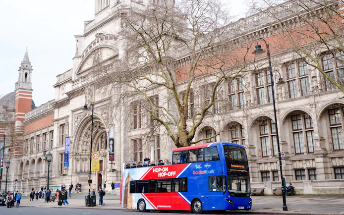 Golden Tours hop-on hop-off bus in front of the Victoria and Albert Museum, London.
