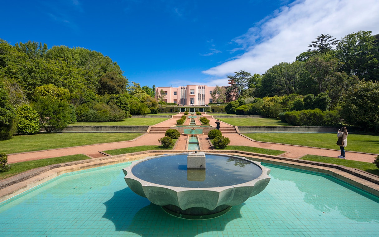 Serralves Museum garden with fountain and pink Art Deco building in Porto, Portugal.