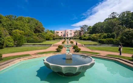 Serralves Museum garden with fountain and pink Art Deco building in Porto, Portugal.
