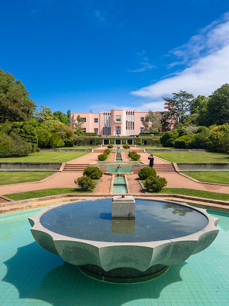 Serralves Museum garden with fountain and pink Art Deco building in Porto, Portugal.