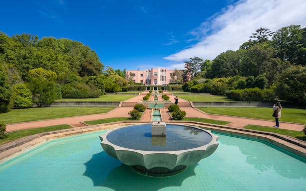 Serralves Museum garden with fountain and pink Art Deco building in Porto, Portugal.